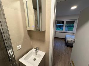 a small bathroom with a sink and a window at Cozy Room Echterdingen Stuttgart Airport & Messe in Leinfelden-Echterdingen