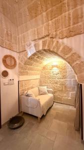 a room with a couch in front of a stone wall at Luxury Vittoria in Ceglie Messapica