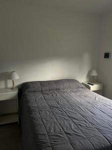 a bed in a bedroom with two nightstands and two lamps at Refugios del Parque in Necochea