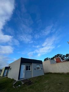 a house with a blue roof on top of a yard at Refugios del Parque in Necochea +7 photos