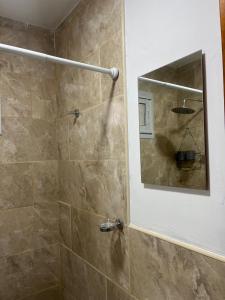 a bathroom with a shower with a mirror at Refugios del Parque in Necochea