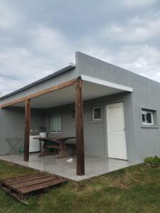 a house with a large covered patio with a table at Refugios del Parque in Necochea