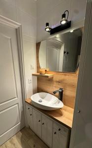 a bathroom with a white sink and a mirror at Apartament W Cieniu Twierdzy in Kłodzko +7 photos