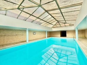 a swimming pool with blue water in a building at NCHouse in Esposende