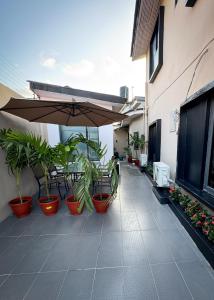a patio with plants and an umbrella on a building at Luxe Apartments Surulere in Lagos