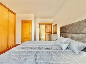 a bedroom with a large bed with a large headboard at NCHouse in Esposende