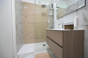 a bathroom with a shower with a sink and a counter at Arabia Suites in Cosenza