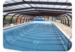 a large swimming pool with blue water at The cosy house in Corton