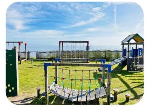 a park with a playground with a play equipment at The cosy house in Corton