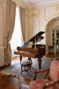 a living room with a piano in a room at Château La Rametière in Le PARC +16 photos