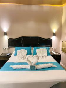 a bed with two white towels in the shape of a heart at Hotel Lince in Lima
