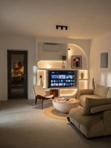a living room with a couch and a tv at Faragas Hill Harmony Villa in Angairiá