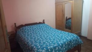 a bedroom with a bed with a blue comforter at Hostal Inca in Sucre