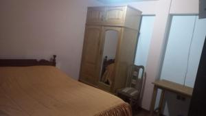 a bedroom with a bed and a dresser with a mirror at Hostal Inca in Sucre