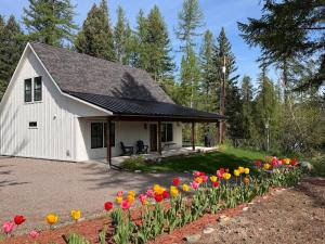 a white house with flowers in a yard at Hungry Horse Farmhouse in Hungry Horse