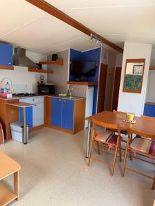 a kitchen with blue cabinets and a wooden table at Horizon Marin Escapade bord de mer à Cancale in Cancale