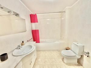 a white bathroom with a red shower curtain and a toilet at NCHouse in Esposende +13 photos