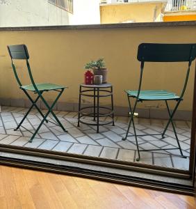 two chairs and a table on a tile floor at Mille4 in Novara