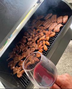 a person holding a glass of wine next to a grill at Noce Melano in Montattico