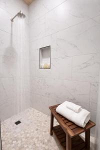 a white bathroom with a shower and a wooden table at Sommer House Inn-Aloha Room in Jasper