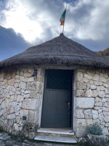 a stone building with a flag on top of it at Noce Melano in Montattico