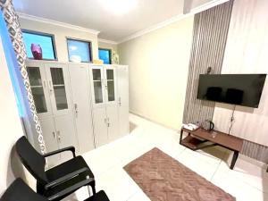 a living room with two chairs and a television at Coco Caribbean Lodge in Accra