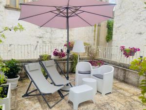 a purple umbrella and some chairs and a table and chairs at Porta Blu Apulia in Martina Franca