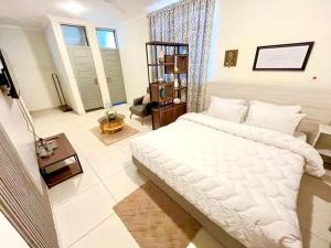 a bedroom with a large white bed in a room at Coco Caribbean Lodge in Accra