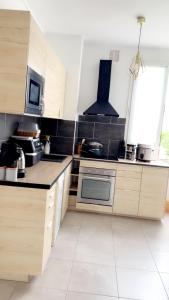 a kitchen with wooden cabinets and a stove top oven at Laurier-Rose Gîte in Châteaudun +3 photos