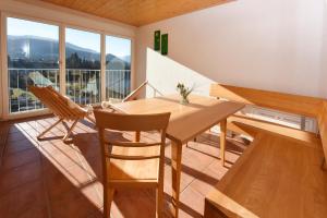 a dining room with a table and chairs and a balcony at Ferienhof Dürlinde in Hittisau