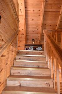 a staircase in a log cabin with wooden ceilings at Laurel Lake Cabins in Corbin