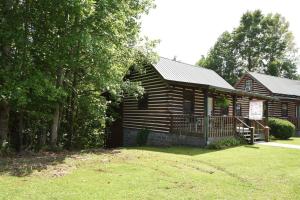 a log cabin with a yard in front of it at Laurel Lake Cabins in Corbin