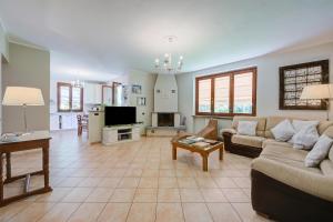 a living room with a couch and a tv at Villa La Dolce Vita: Lake Maggiore 3BR, Fenced Garden, Parking near Beaches - Happy Rentals in Leggiuno