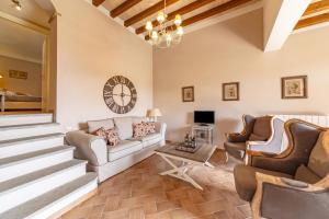 a living room with a couch and chairs and a clock at Il Conventaccio Luxury Resort in Ficulle