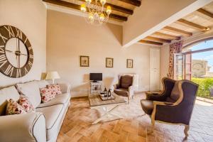 a living room with a couch and chairs and a clock at Il Conventaccio Luxury Resort in Ficulle