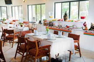 a dining room with white tables and chairs at Hotel Misión San Miguel de Allende in San Miguel de Allende