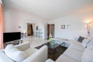a living room with two white couches and a tv at Casa Monti Belvedere with Pool + Terrace Dining - Happy Rentals in Locarno