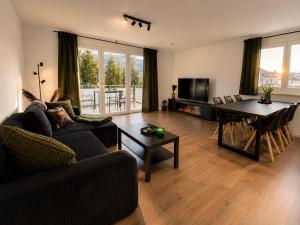a living room with a table and a dining room at Design Apartment 6 am Titisee mit Kamin, E-Ladestation, Balkon, Top Lage in Titisee
