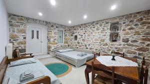 a living room with a stone wall at Summerstone Cottage in Aliveri