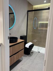 a bathroom with a sink and a glass shower at La Encina Suites in Salamanca
