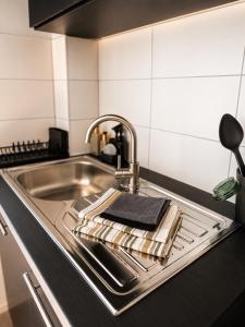 a kitchen sink with a towel on the counter at Design Apartment 6 am Titisee mit Kamin, E-Ladestation, Balkon, Top Lage in Titisee