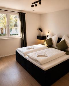 a large bed in a room with a window at Design Apartment 6 am Titisee mit Kamin, E-Ladestation, Balkon, Top Lage in Titisee