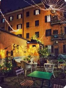 a patio with tables and chairs and a building with lights at Milano Brenta Suites Room for 4 in Milan