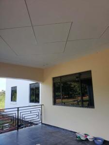 an empty room with two windows and a white wall at Sunset Grove in Pakwach East
