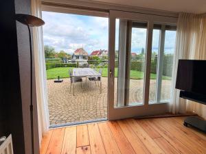 a sliding glass door leading to a patio with a table at Villa Water en Meer in Terherne +26 photos