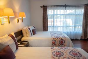 a hotel room with two beds and a window at Hotel Misión San Miguel de Allende in San Miguel de Allende