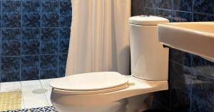a bathroom with a white toilet and a sink at Hotel Posada Casa de la Tía in Oaxaca City
