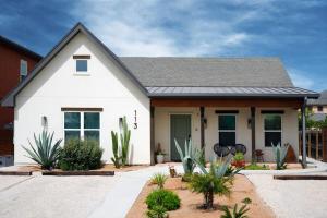 a white house with plants in front of it at Orion A 3BR Heated Pool with Desk and Laundry in Port Isabel