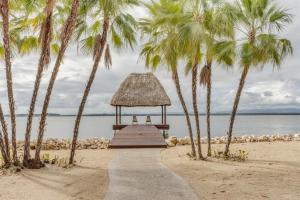 a gazebo on a beach with palm trees at Luxury Waterfront 3bd Villa w Pool Dock in Maya Beach