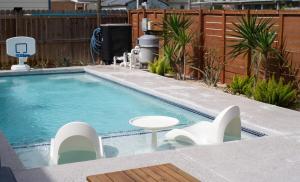 a swimming pool with a table and chairs in a backyard at Orion A 3BR Heated Pool with Desk and Laundry in Port Isabel